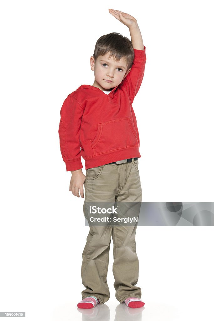 Little boy shows his height Serious little boy shows how he is tall Boys Stock Photo