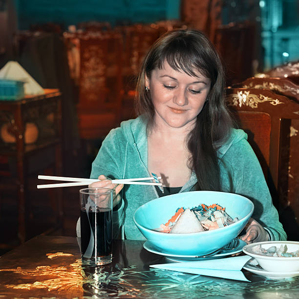 Young woman enjoys her meal in Asian restaurant