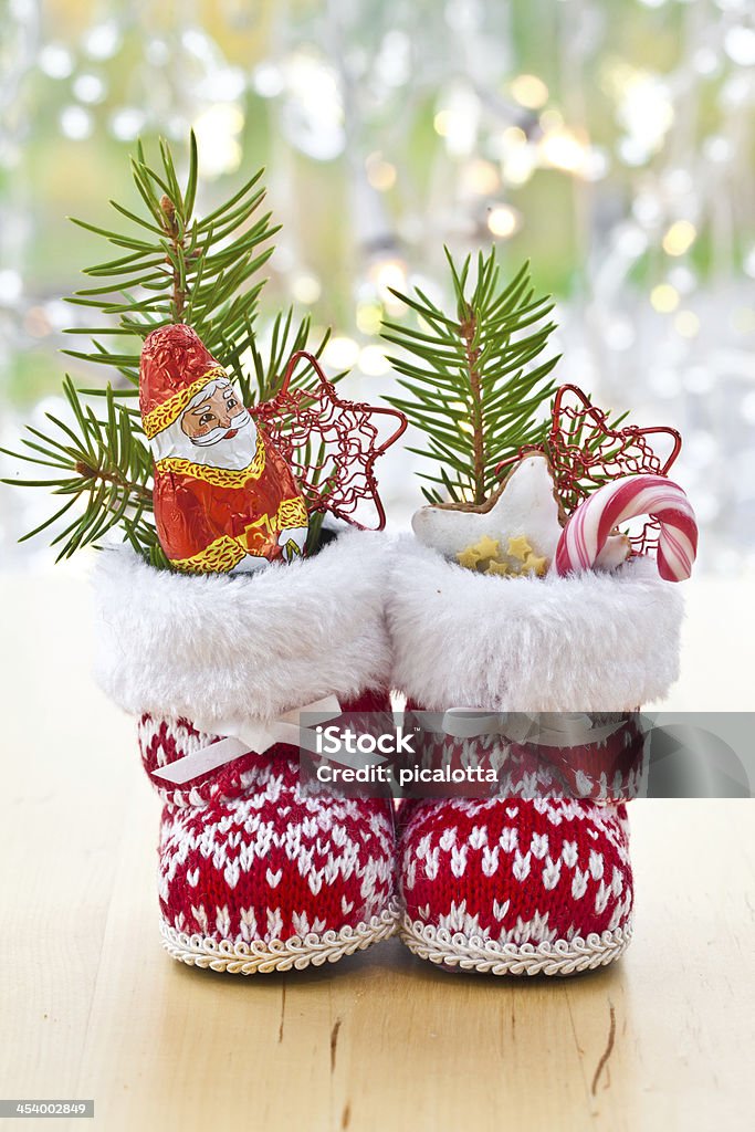 Little boots filled with sweets Little boots filled with sweets for christmas Santa Claus Stock Photo