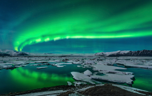 Spectacular auroral display over the glacier lagoon Jokulsarlon in Iceland.