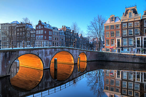 Bridge lights reflection Beautiful early morning winter view on one of the Unesco world heritage city canals of Amsterdam, The Netherlands. HDR canal house photos stock pictures, royalty-free photos & images