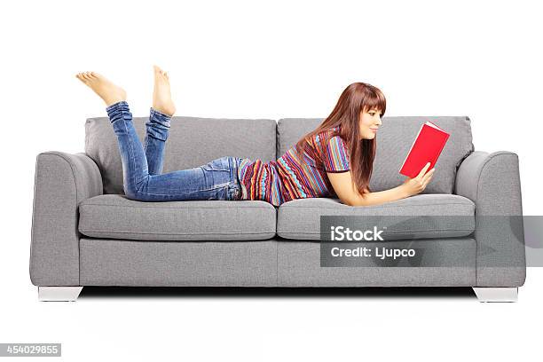 Young Female Lying On Sofa And Reading A Book Stock Photo - Download Image Now - Adult, Adults Only, Backgrounds