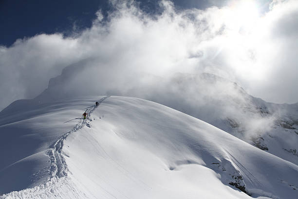 istock Skiers climbing a snowy mountain 454031451