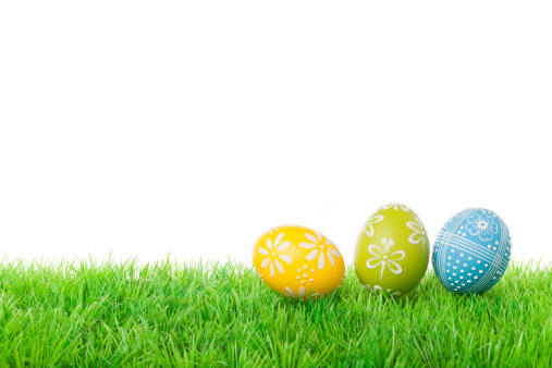 Colorful easter eggs on meadow over white background.