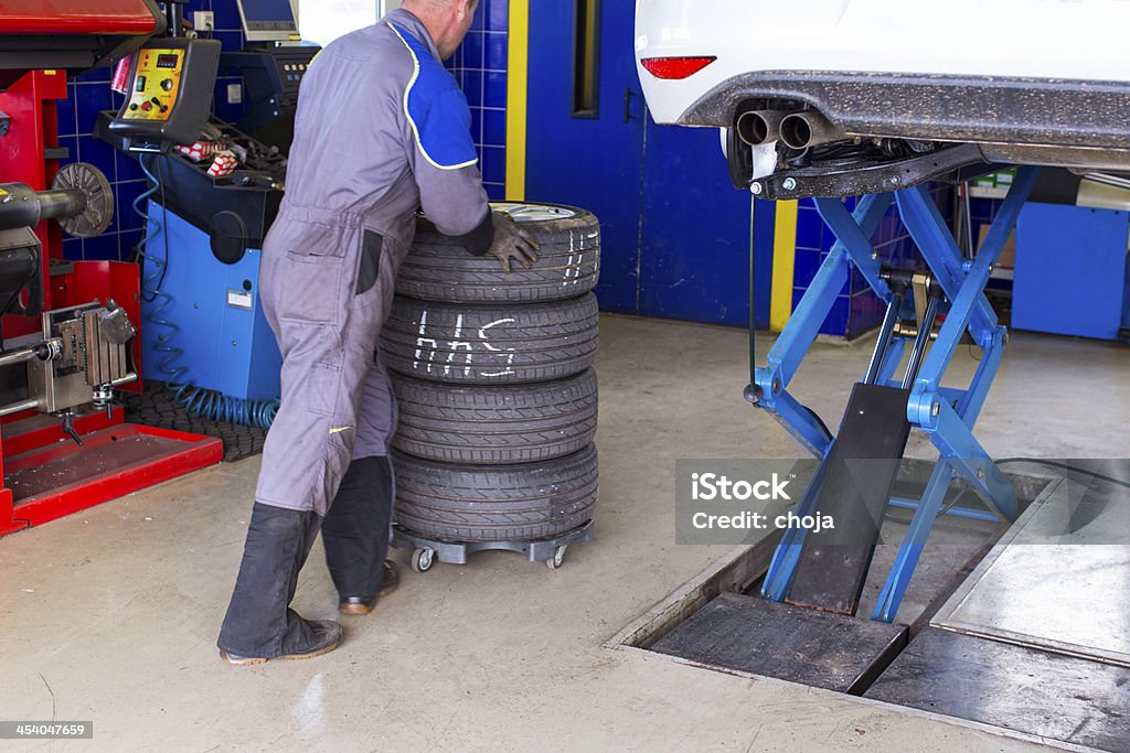 Mécanicien automobile est changin tire.prepairing voiture pour l'hiver - Photo de Aluminium libre de droits