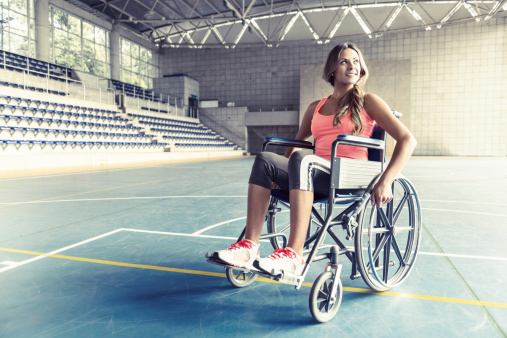 Injured sports woman in a wheelchair at a basketball court