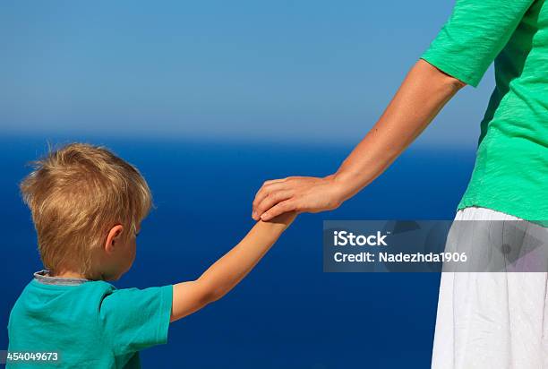 Mother And Son Holidng Hands On Sea Vacation Stock Photo - Download Image Now - Child, Parent, Adult