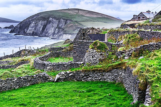 Ruined stone dwelling with beehive hut, Ireland  dingle bay stock pictures, royalty-free photos & images
