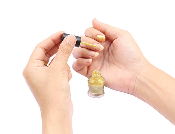 istock female hand with a golden nail polish on white background 454071977