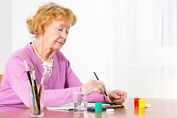 istock Senior woman painting 454097191