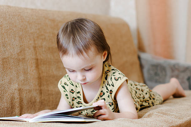 istock Beautiful cute baby reading a book 454100153
