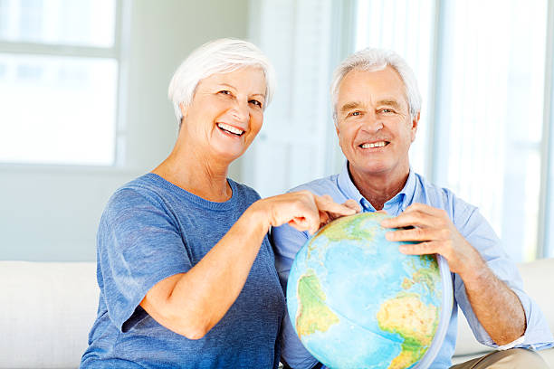 istock Couple Choosing Travel Destination From Globe At Home 454103457