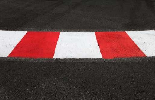 Texture of motor race asphalt and re white curb. Close up on Monaco Montecarlo Grand Prix street circuit