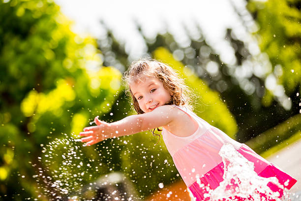 istock Cheerful girl splashing water with hand 454124109