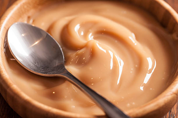 istock Wooden bowl of dulce de leche with a silver spoon 454124815