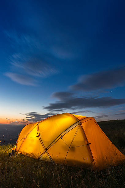 istock Colourful mountain tent glowing on summit beneath blue dusk skies 454135495