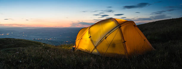 istock Vibrant dome tent on mountain overlooking sunset lights in valley 454135537