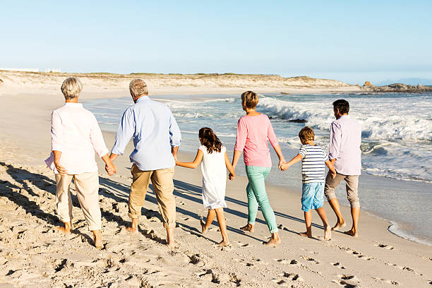 istock Multi-Generation Family Holding Hands While Walking On The Beach 454135655