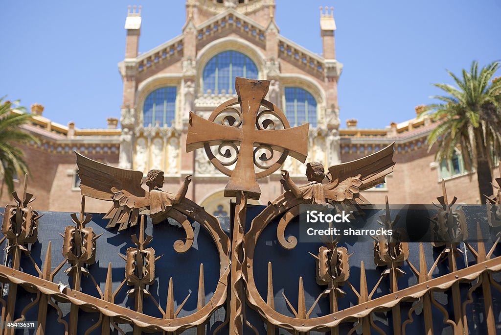 Hospital de Sant Pau in Barcelona, Spain Crucifix and angels adorning the entrance gates to the old Hospital de Sant Pau in Barcelona, Spain which is currently being renovated Hospital Stock Photo