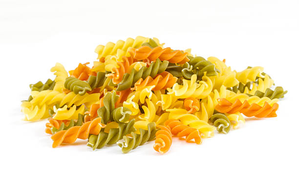 istock Uncooked pasta fusilli in different colours, white background 454139295