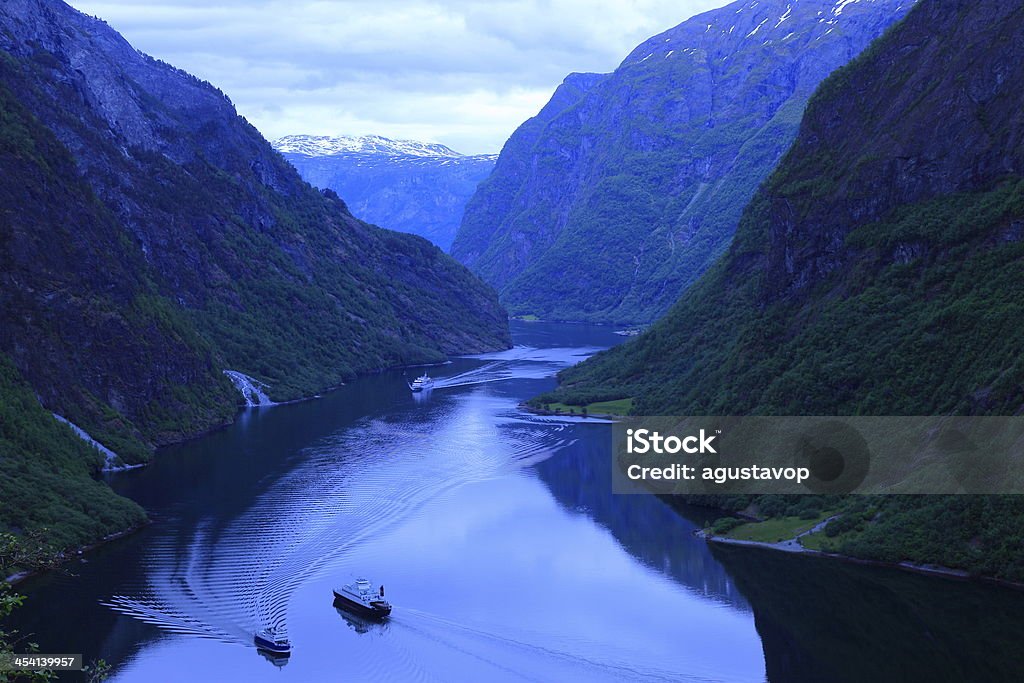 Naeroyfjord mountains and ship cruises crossing water, Norway View of Naeroyfjord - famous UNESCO World Heritage Site in Norway - from Rimstigen, a steep path from the carroad Gudvangen-Bakka appr. 500 metres after the church at Bakka. Aerial View Stock Photo