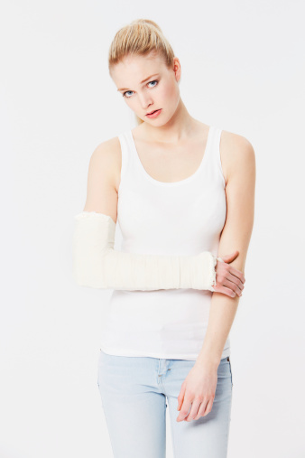 Portrait of an unhappy girl with a bandaged arm