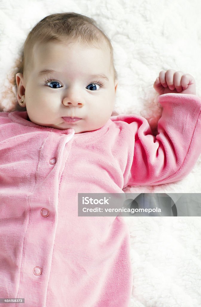 Cute baby girl lying on the bed cute baby girl lying on the bed and looking at camera Baby - Human Age Stock Photo