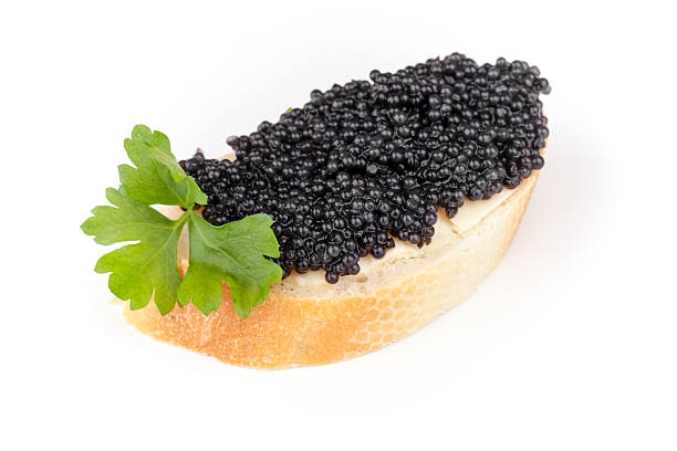 istock Small sandwich with black caviar isolated on white background 454163913