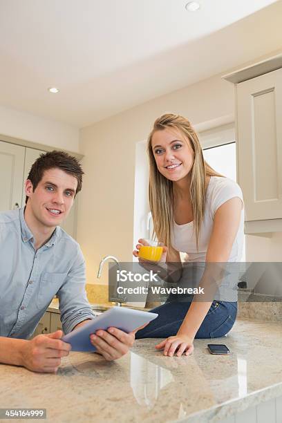 Man Holding Tablet Pc And Woman Drinking Orange Juice Stock Photo - Download Image Now