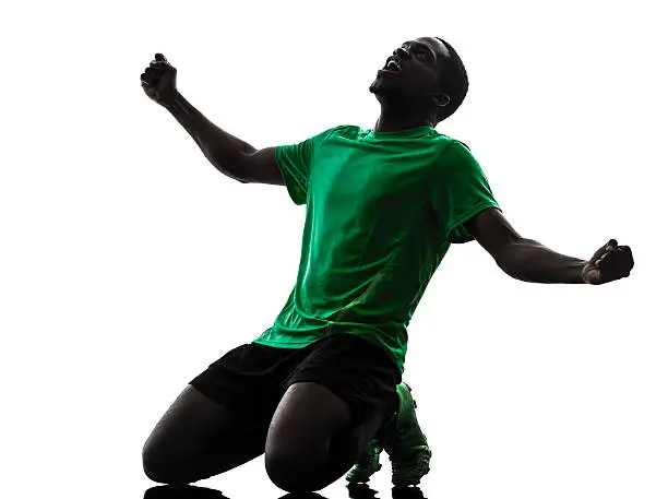 Photo of african man soccer player celebrating victory silhouette