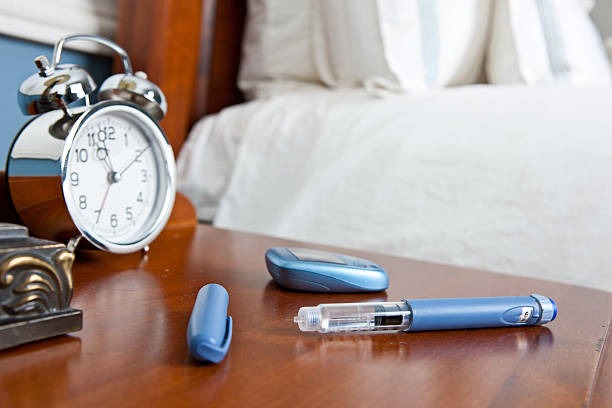 insuline plume et glucometer sur la table de nuit - insulin diabetes pen injecting photos et images de collection