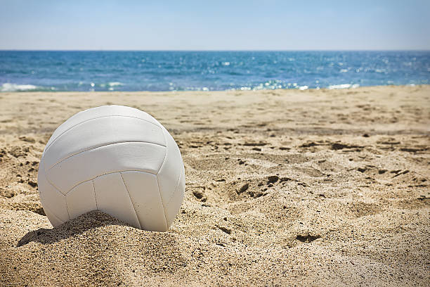 Beach Volleyball White volleyball sits on top of the sand. beach volleyball stock pictures, royalty-free photos & images