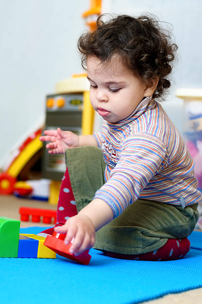 istock Baby Girl Playing With Plastic Building Blocks 454175837