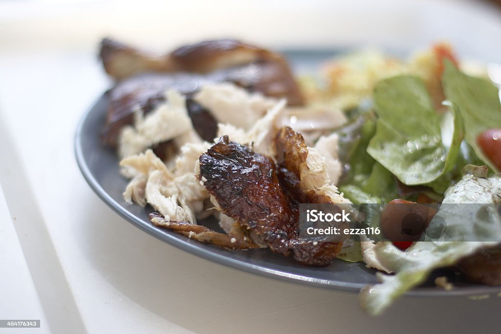 Man Carving Fresh Roast Chicken Fresh Roast Chicken salad on a plate outside with lettuce and tomatoe Chicken - Bird Stock Photo