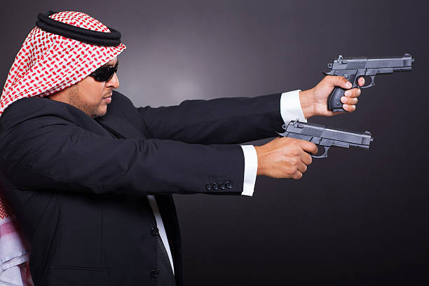 istock arabian hit man shooting with guns 454180483