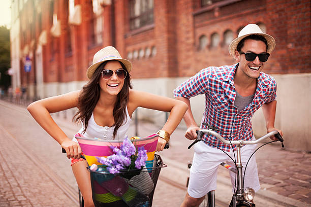 casal equitação bicicletas na cidade - funny scene imagens e fotografias de stock