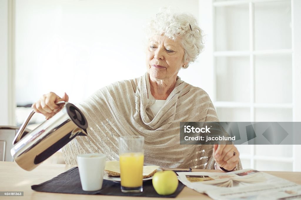 Senior Woman Having Breakfast Portrait of a senior woman having healthy breakfast at home Dining Stock Photo