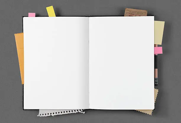 Open notepad with papers, business cards and clipping, post-it