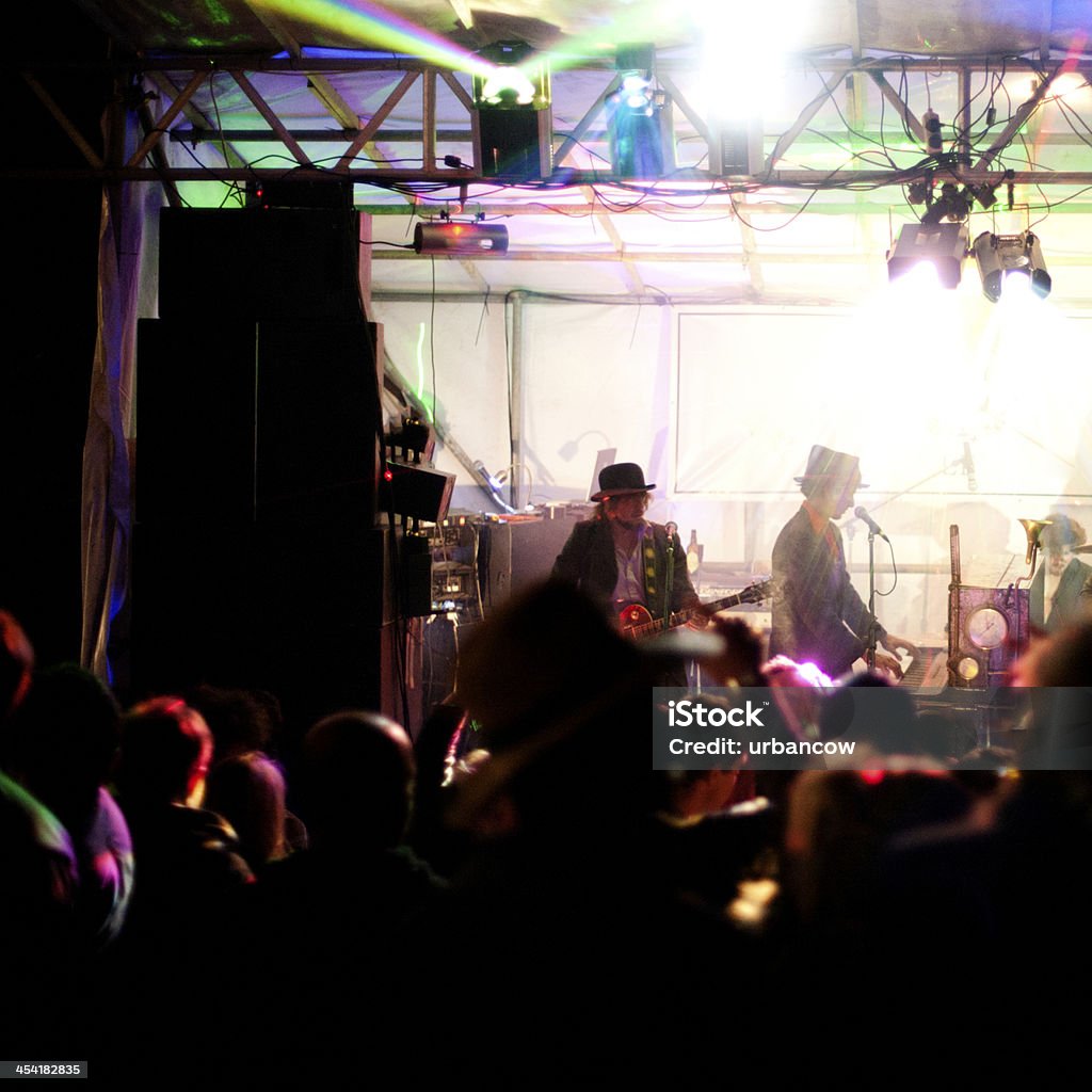 Night at a live music event Festival goers dance outside at a live music festival, Castlewood Wine Festival, Devon Agricultural Field Stock Photo