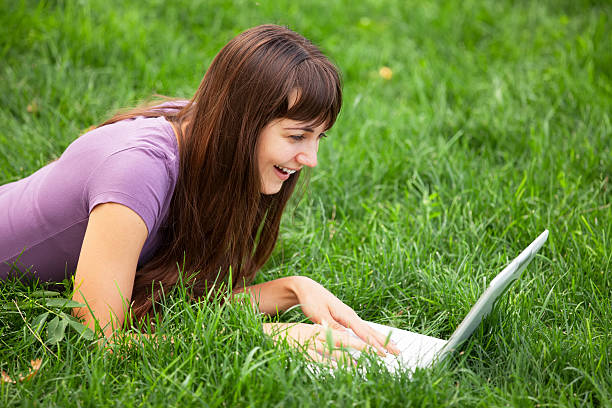 istock Brunette girl at green grass with notebook 454184819