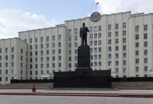 Little girl on the place before a Vladimir Lenin statue and Government building in Mogilev, Belarus, Eastern Europe.