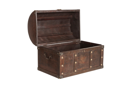 Old leather chest with iron brackets in the corner of the room.