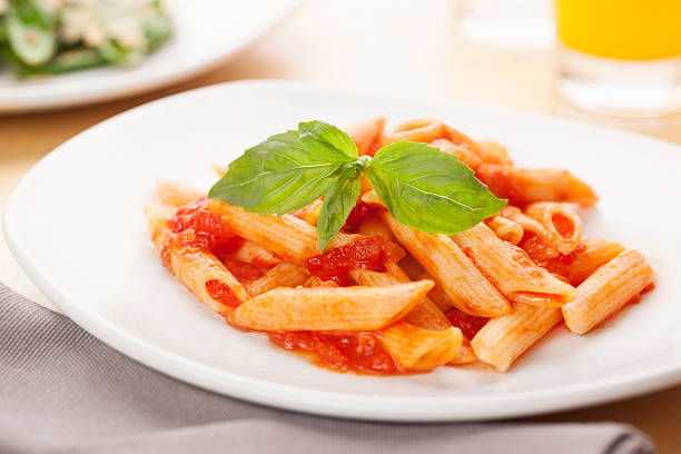 penne mit tomaten-sauce - penne rigatoni pasta tomato pasta stock-fotos und bilder