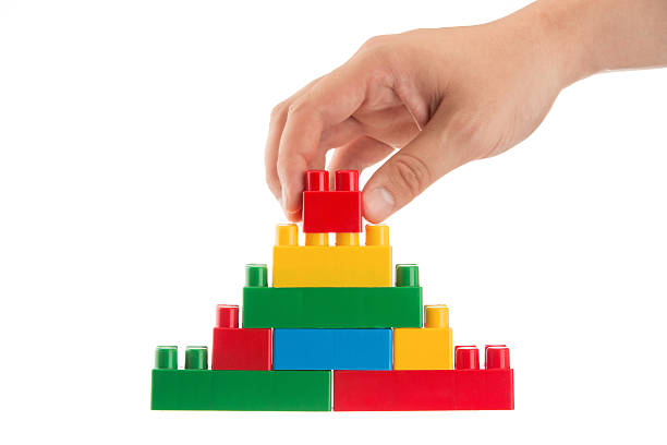 istock Hand building the toy pyramid isolated on white 454191127