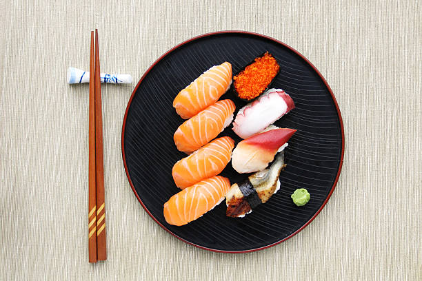 Sushi meal top view top view of a Sushi mix on the plate with chopsticks sushi stock pictures, royalty-free photos & images
