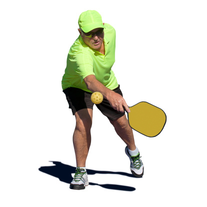 Isolated digital image of a senior man hitting a backhand stroke during a pickleball match.  Image includes clipping mask for player and shadow.