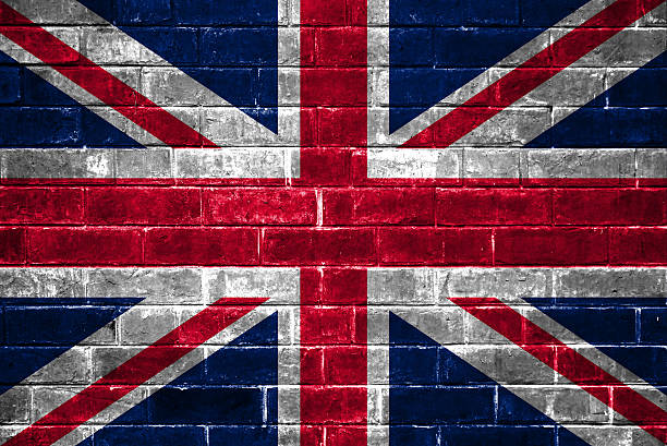 bandera sobre un fondo de pared de ladrillos - british empire flag global uk fotografías e imágenes de stock