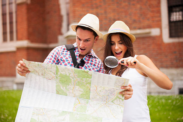 istock Shocked couple looking at map through magnifying glass 454204897