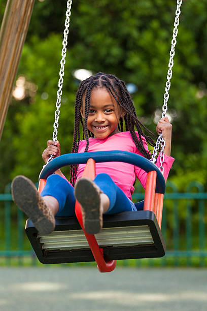 istock Cute young black girl playing with a swing 454209873