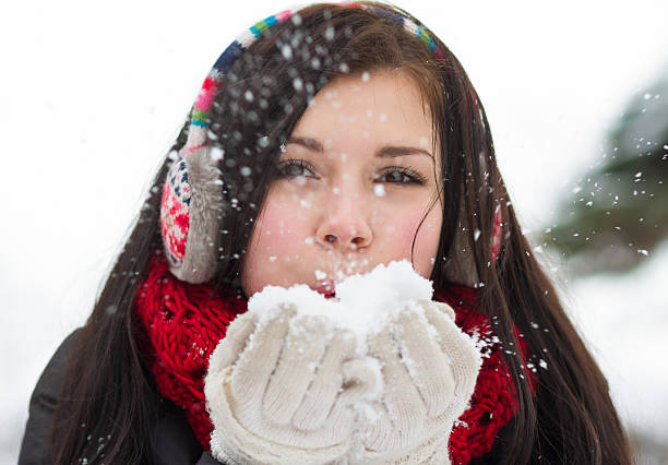 istock Girl blowing fluffy snowflakes 454213683